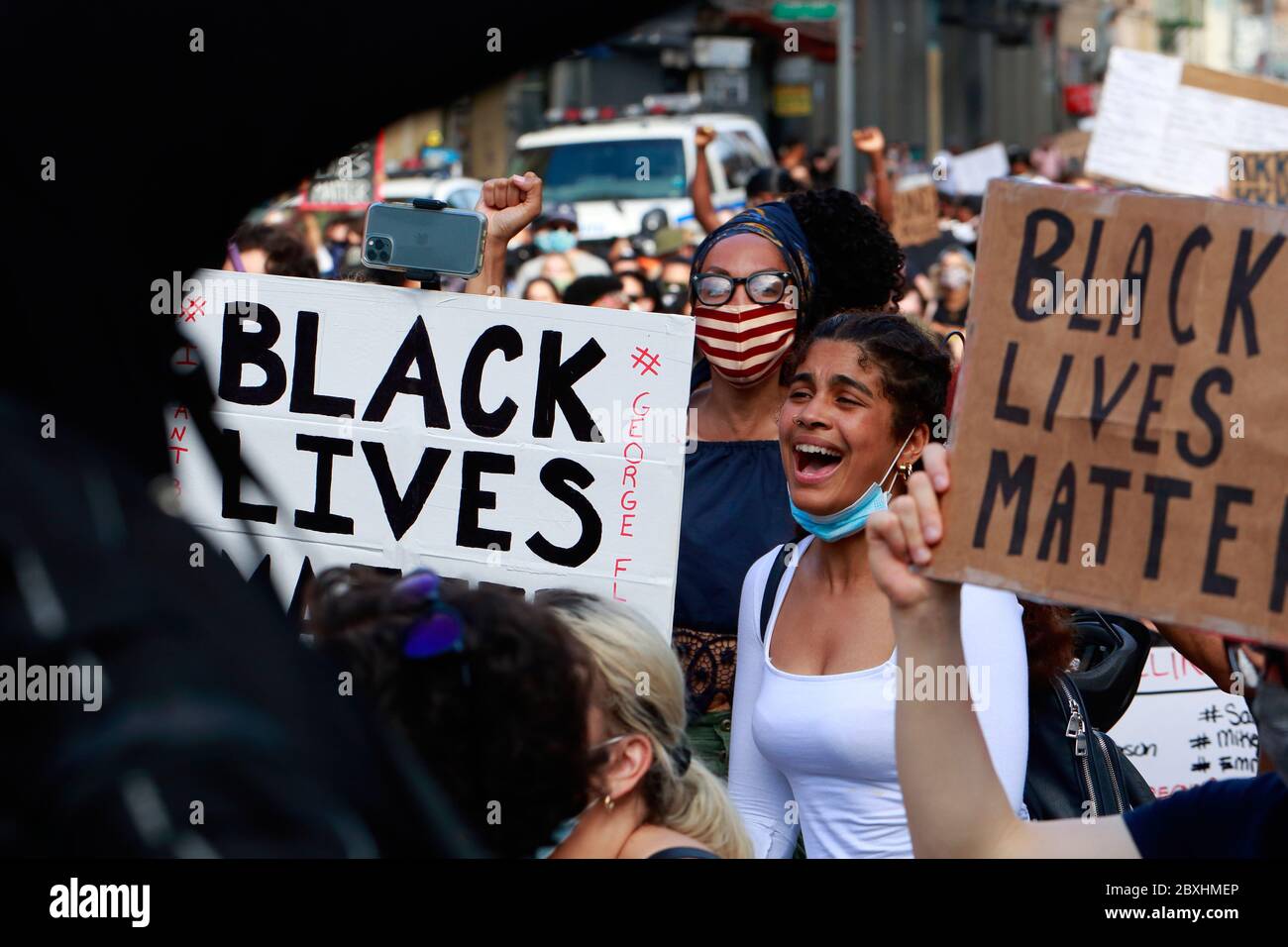 New York, NY. 6th June 2020. Surrounded by 'Black Lives Matter' signs, a woman yells in support at a Black Lives Matter solidarity march through Manhattan calling for justice in a recent string of American police killings: George Floyd, Breonna Taylor, and to countless others. Thousands of people joined in the protest march from Brooklyn crisscrossing Manhattan well past a curfew issued earlier in the week to curb organized burglaries and looting. June 6, 2020 Stock Photo