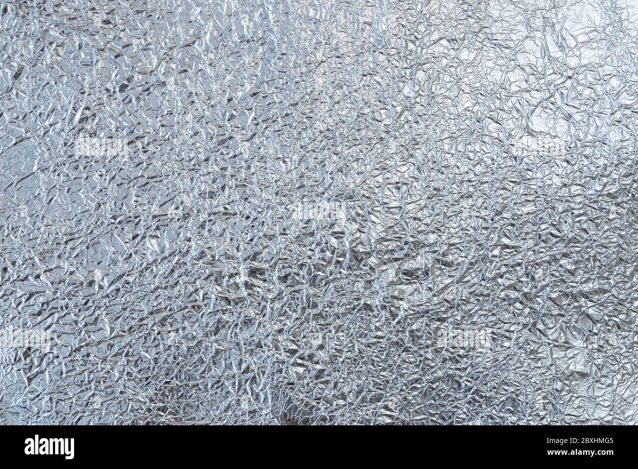 Crumpled tin foil surface, top view. Abstract full frame textured silvery background. Stock Photo