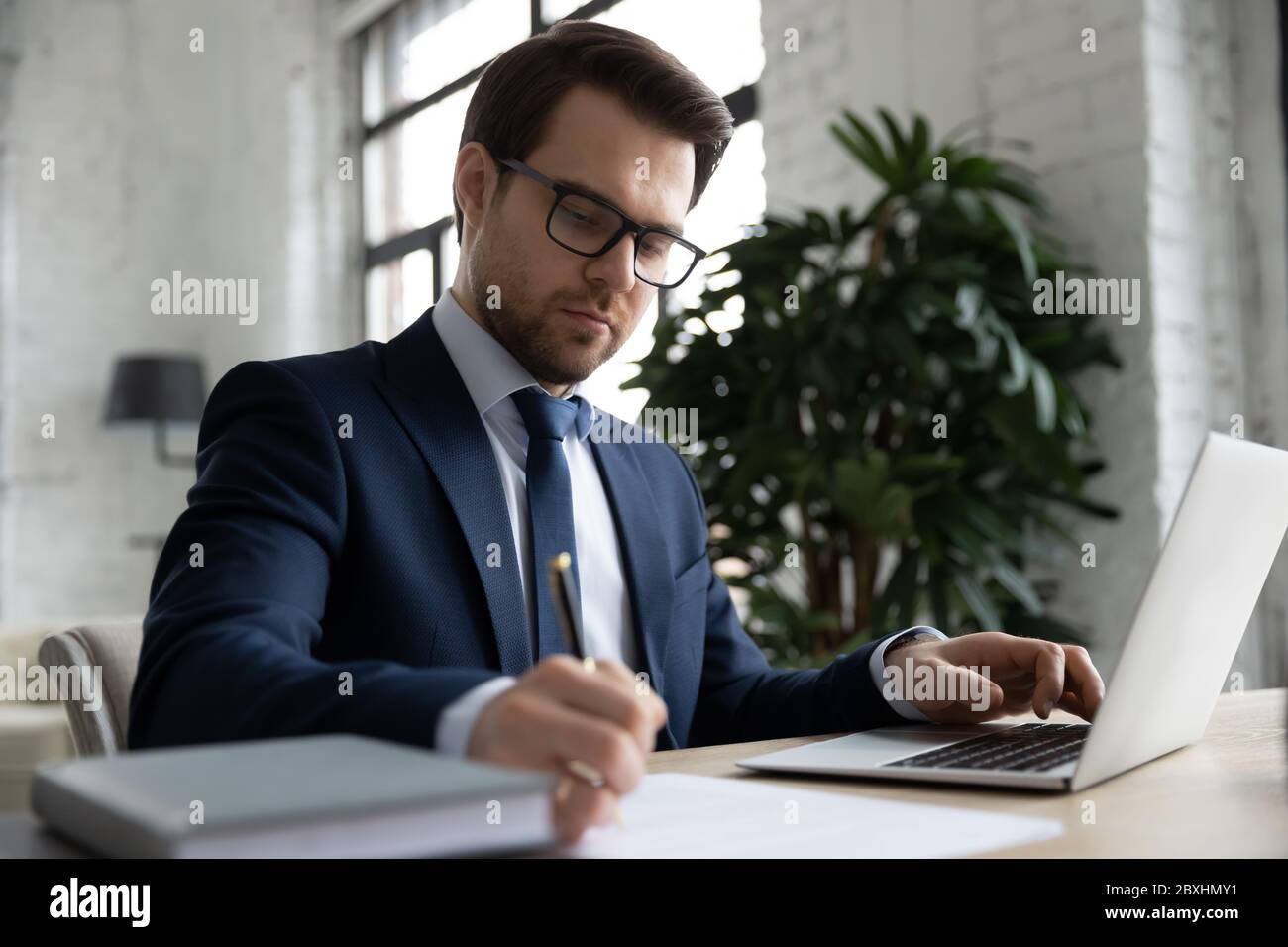 Serious Caucasian employer working making notes in office Stock Photo