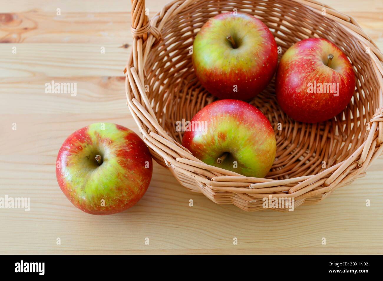 Basket with apples on wooden table, copy space. Stock Photo