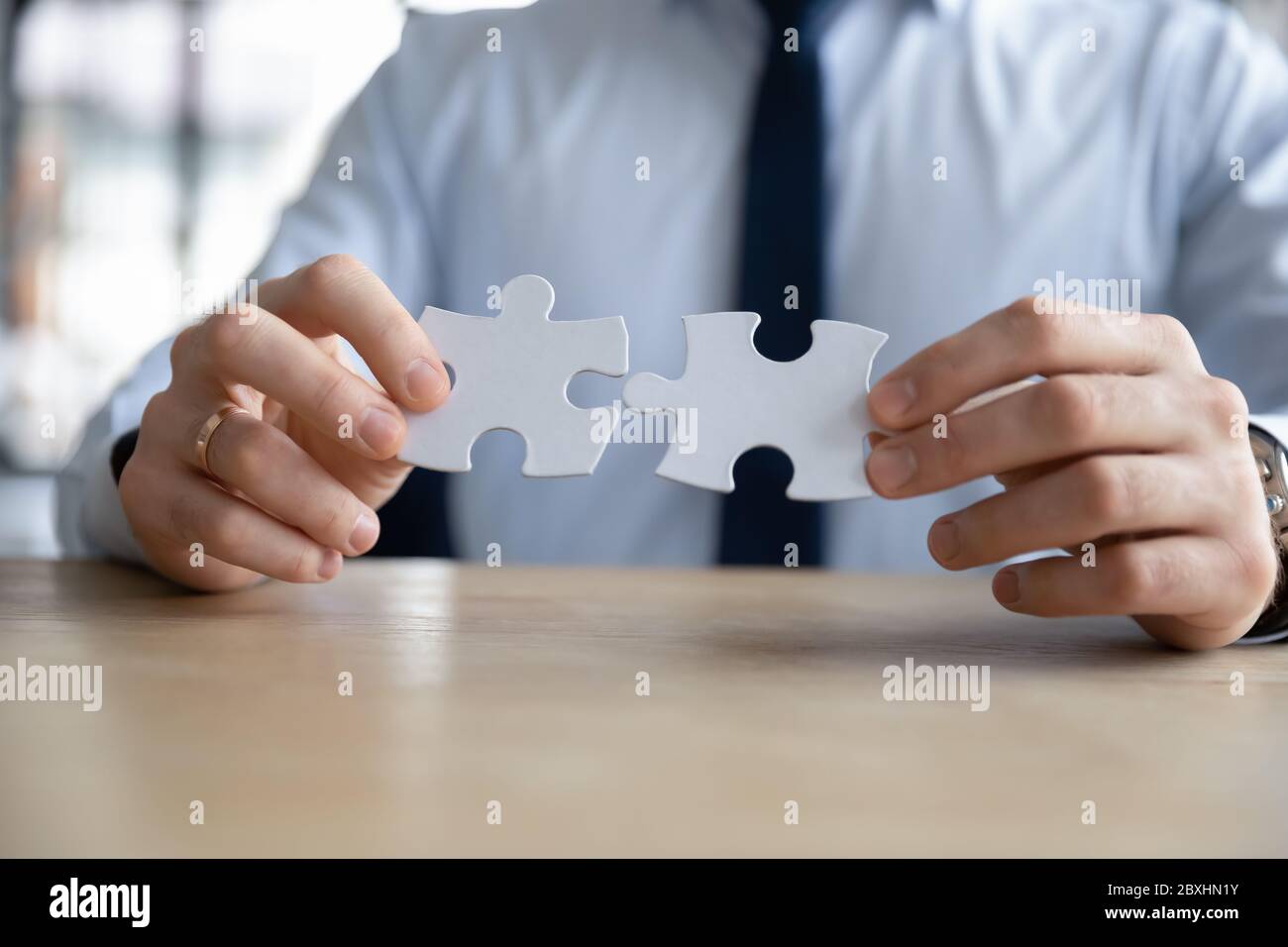 Close up of businessman assemble jigsaw puzzle at workplace Stock Photo