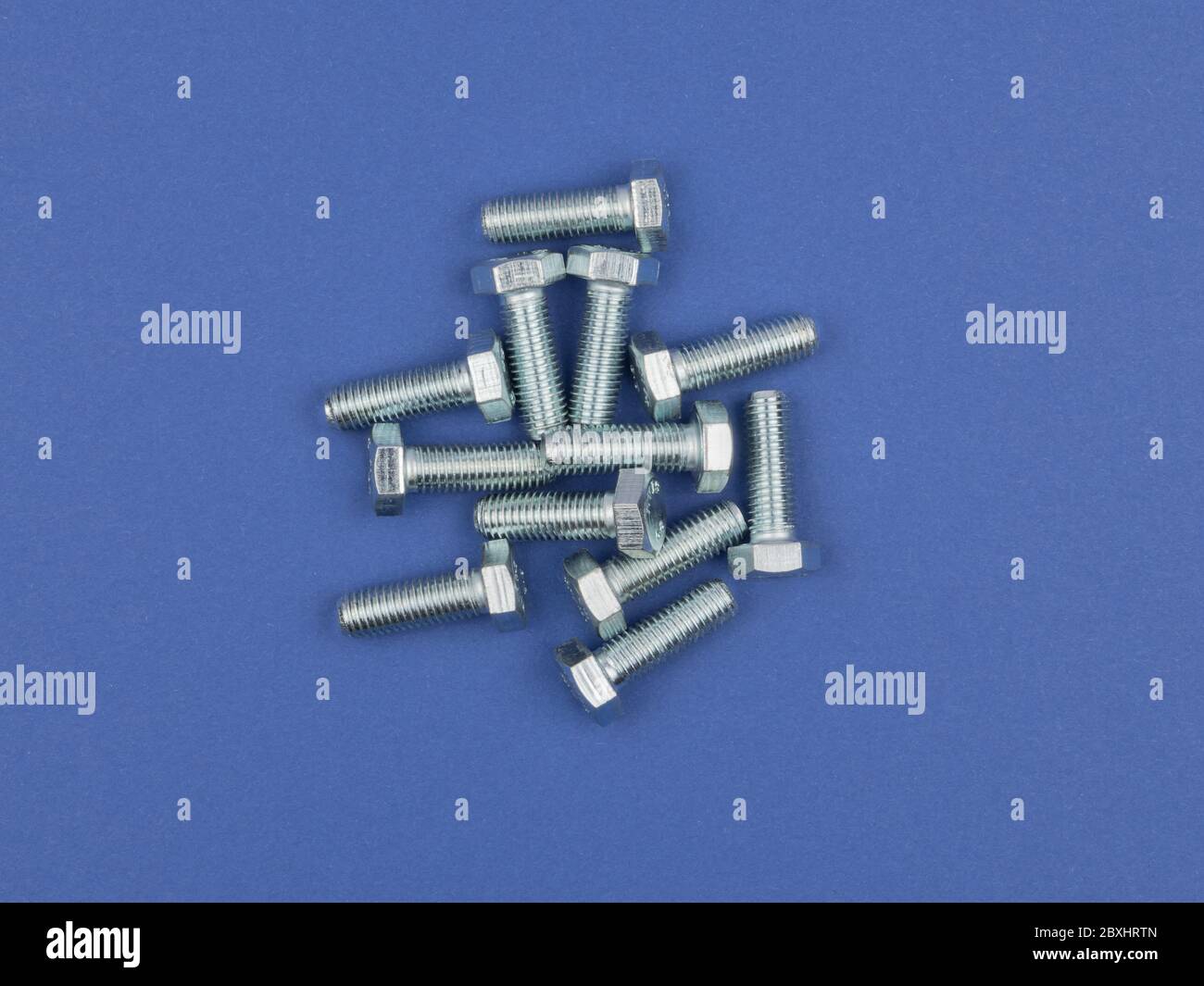Bolts on blue background close-up. Stock Photo