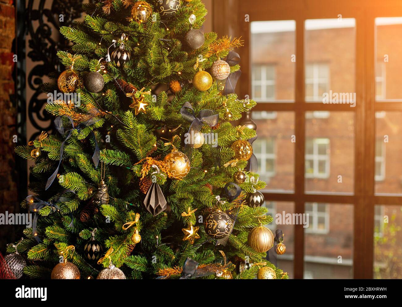 Closeup of a Christmas tree decorated with gold balls and blue bows