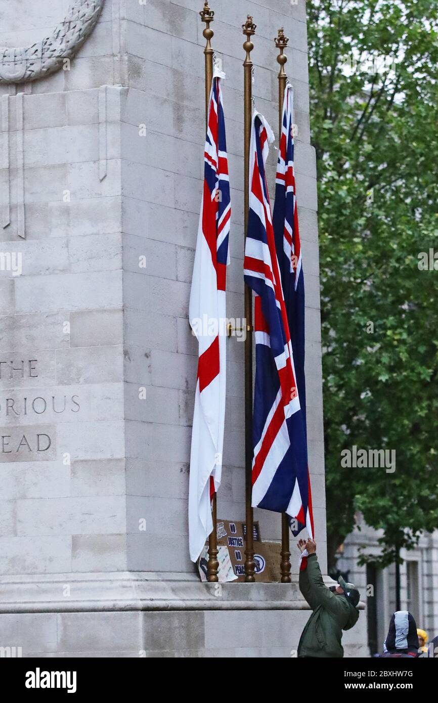 A protester pulls on a flag at the cenotaph in Whitehall, London, during a Black Lives Matter protest rally, in memory of George Floyd who was killed on May 25 while in police custody in the US city of Minneapolis. Stock Photo