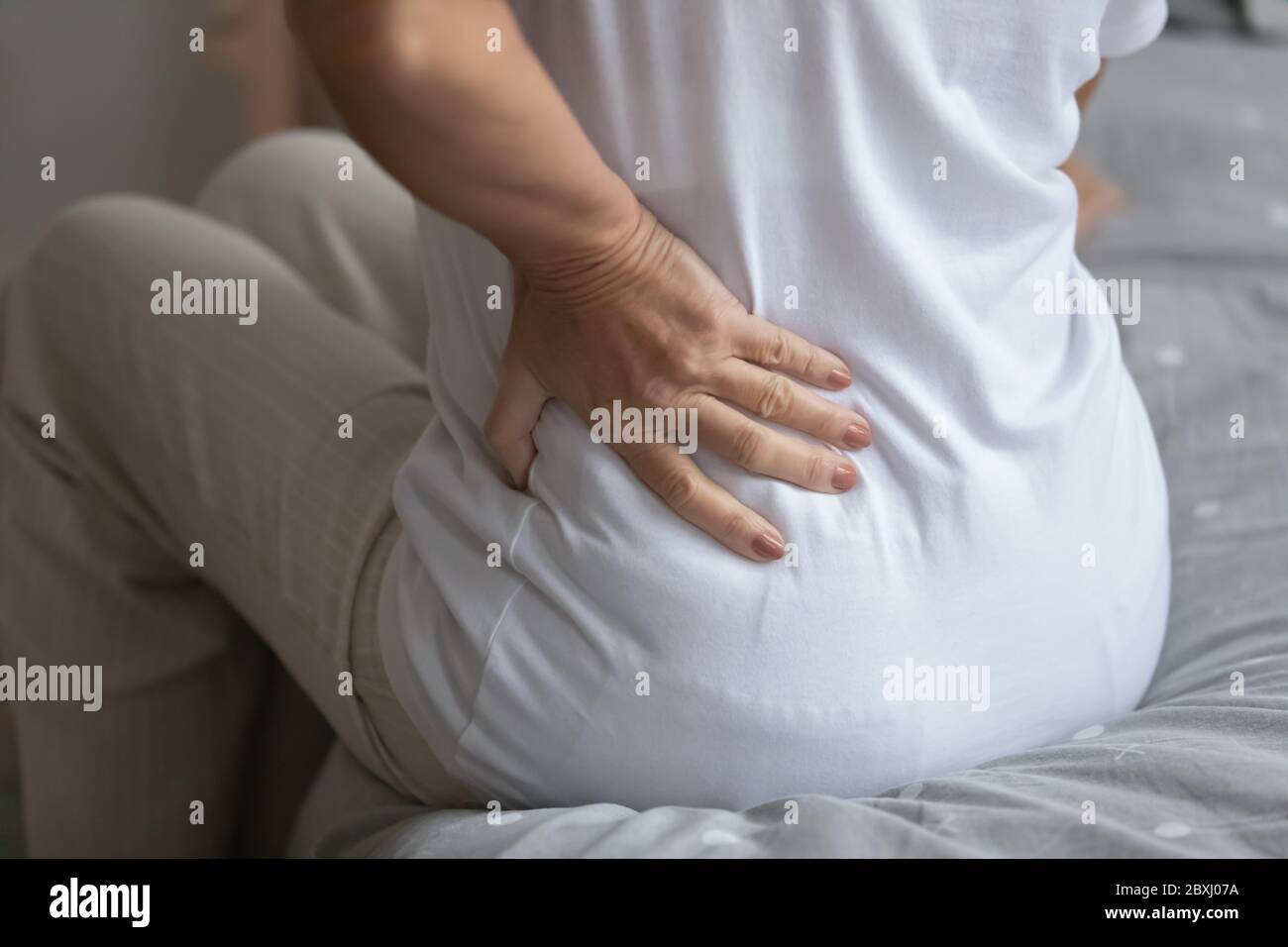 Unhealthy senior woman suffer from lower backache Stock Photo