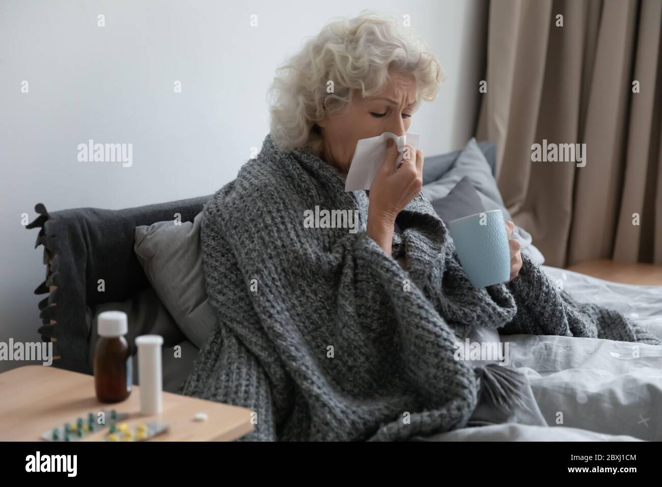 Unhealthy old female sick in home bed Stock Photo