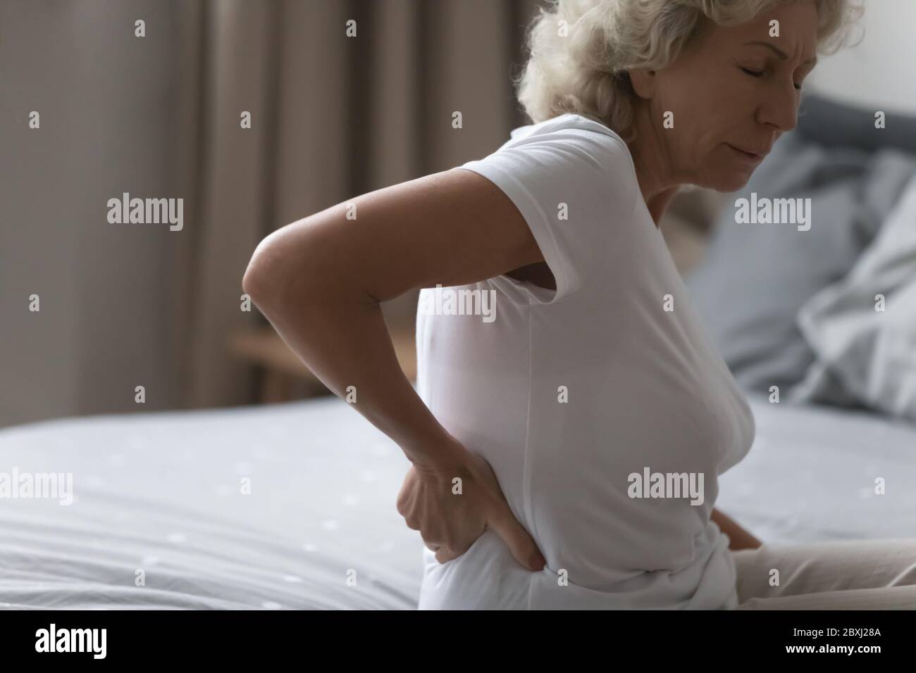 Unwell elderly woman struggle with arthritis at home Stock Photo