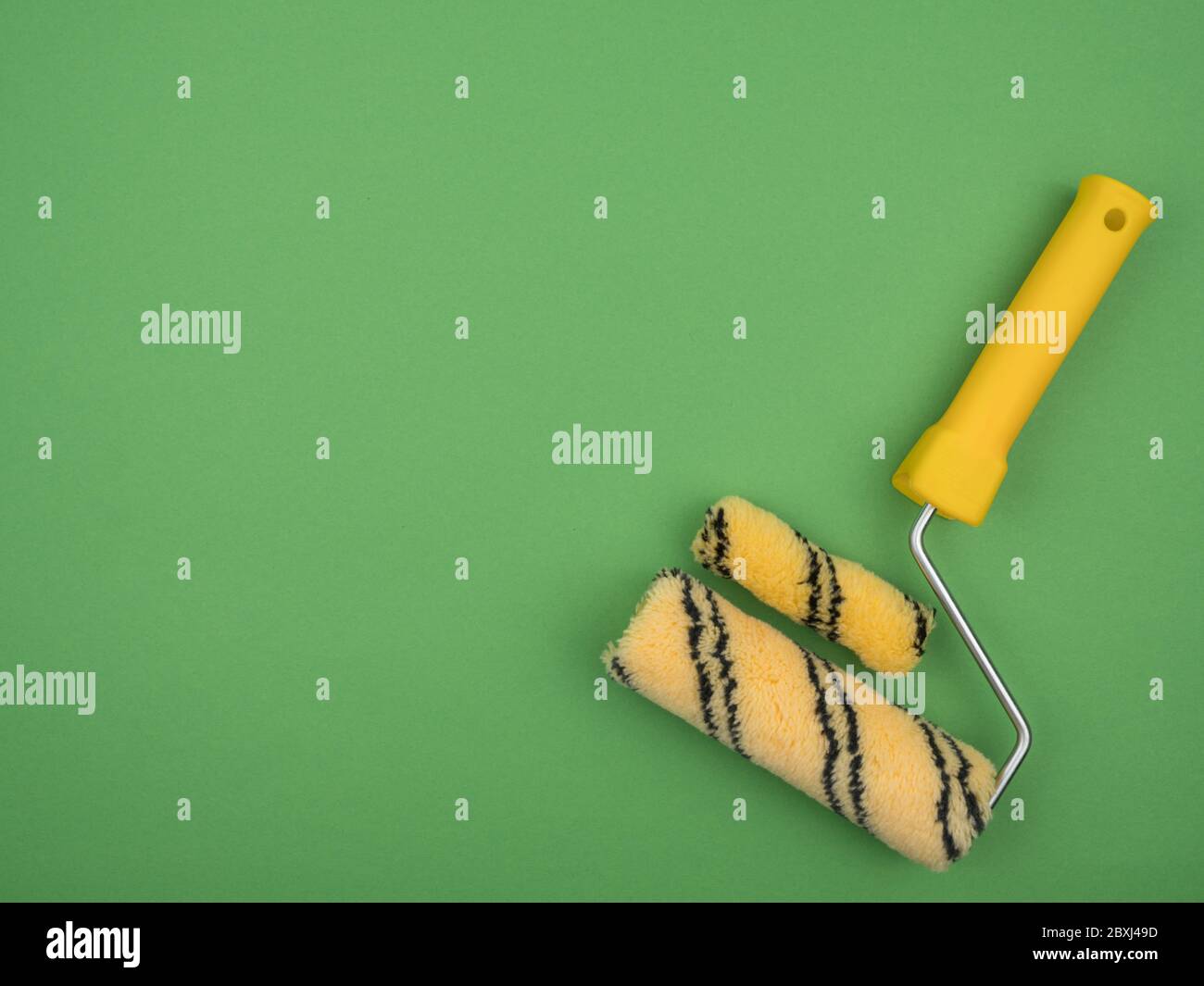 Paint rollers of different sizes on green background Stock Photo Alamy