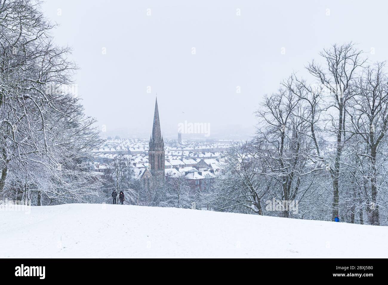 A couple walking  through the Glasgow's Queens Park in heavy snow storm in Glasgow. Stock Photo