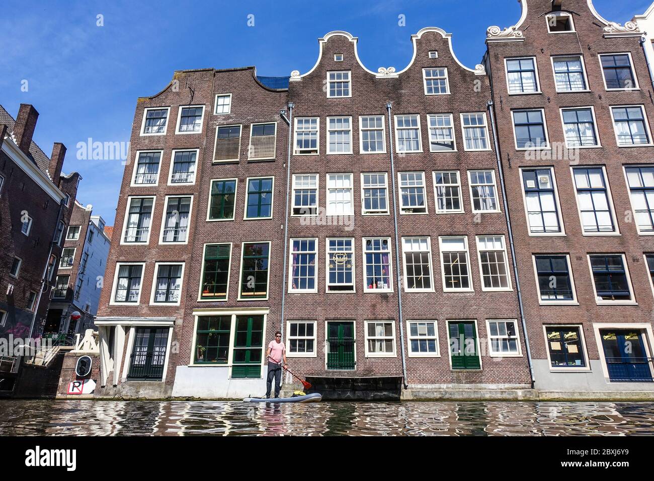 Man on a SUP (standup paddle board) on the canals in the center of