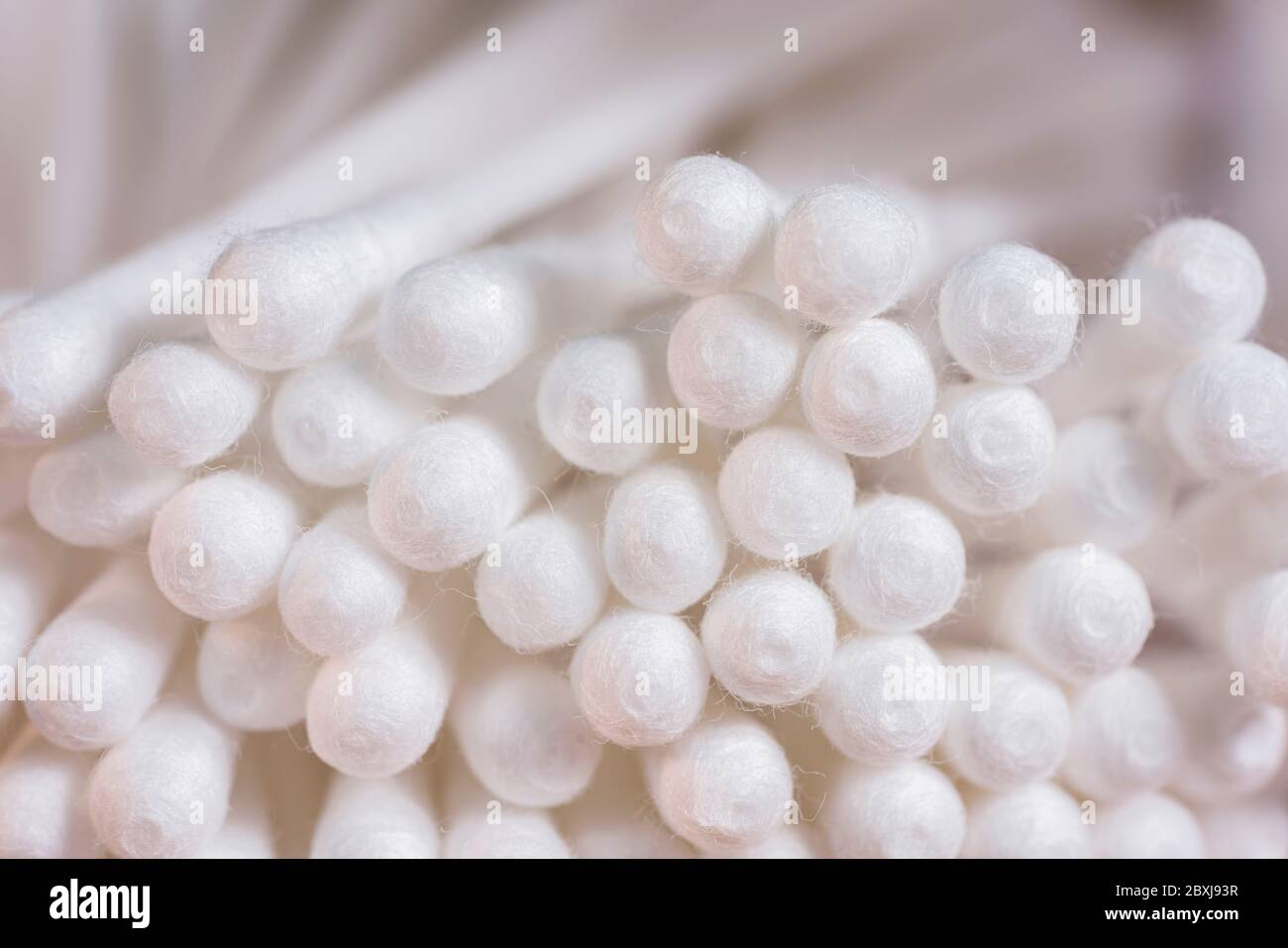 White cotton-tipped swabs background. Ear sticks close up. Soft focus image. Stock Photo