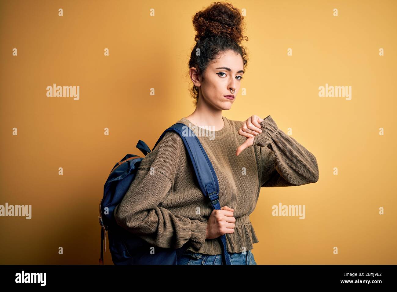 Young beautiful student woman with curly hair and piercing wearing ...