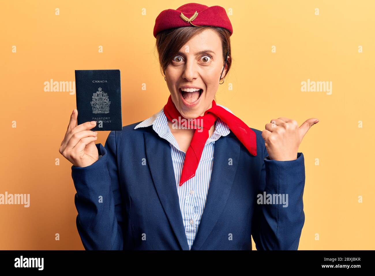 Young beautiful woman wearing stewardess uniform holding canadian ...