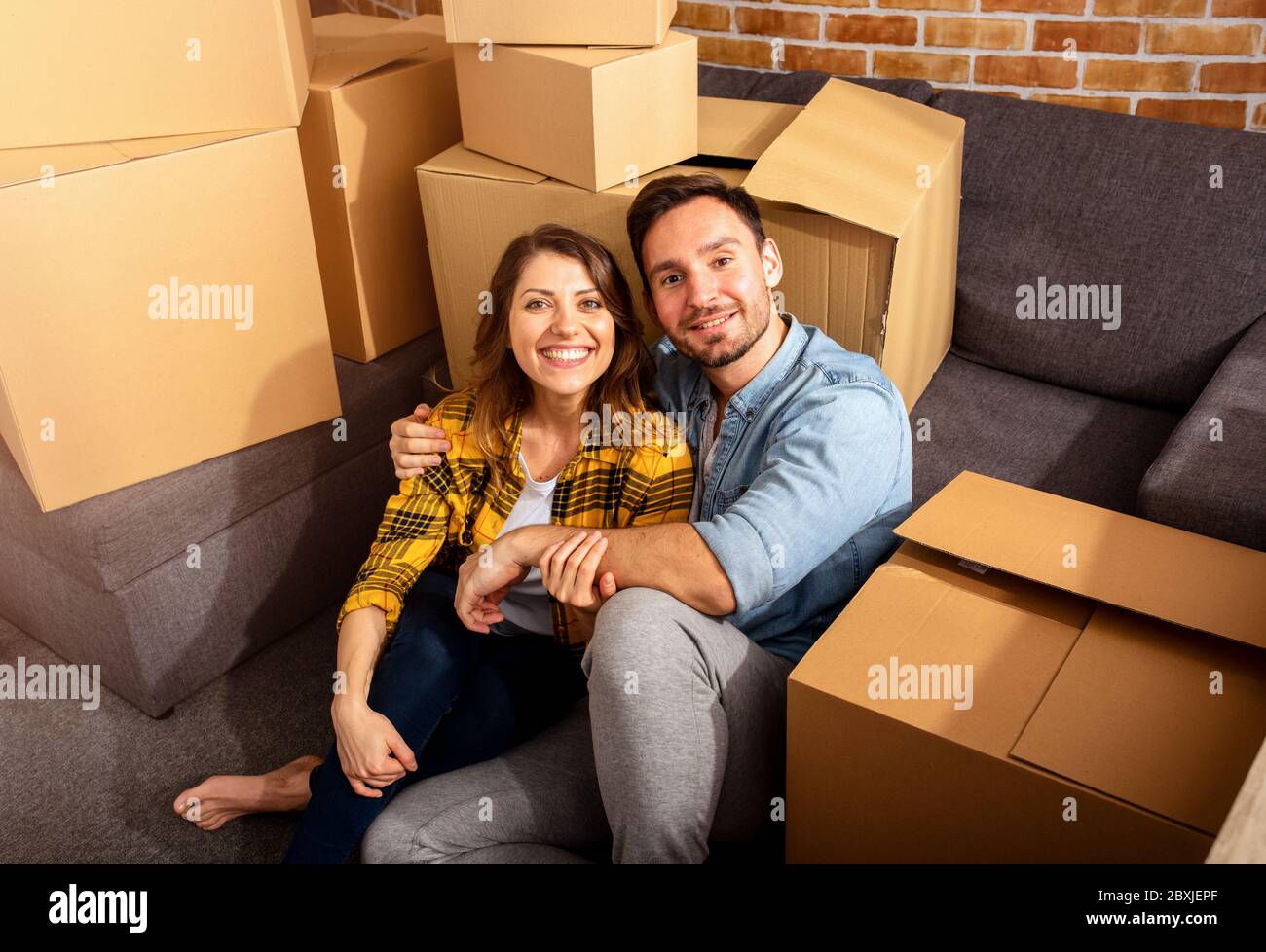 Happy couple have to move and arrange all the packages. Concept of success, change, positivity and future Stock Photo