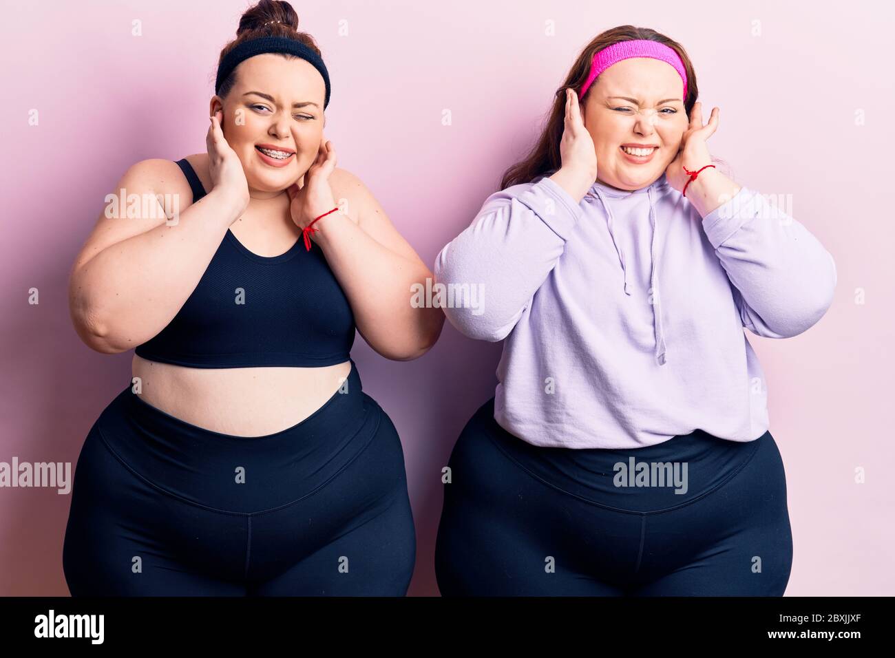 young-plus-size-twins-wearing-sportswear-covering-ears-with-fingers-with-annoyed-expression-for-the-noise-of-loud-music-deaf-concept-2BXJJXF.jpg