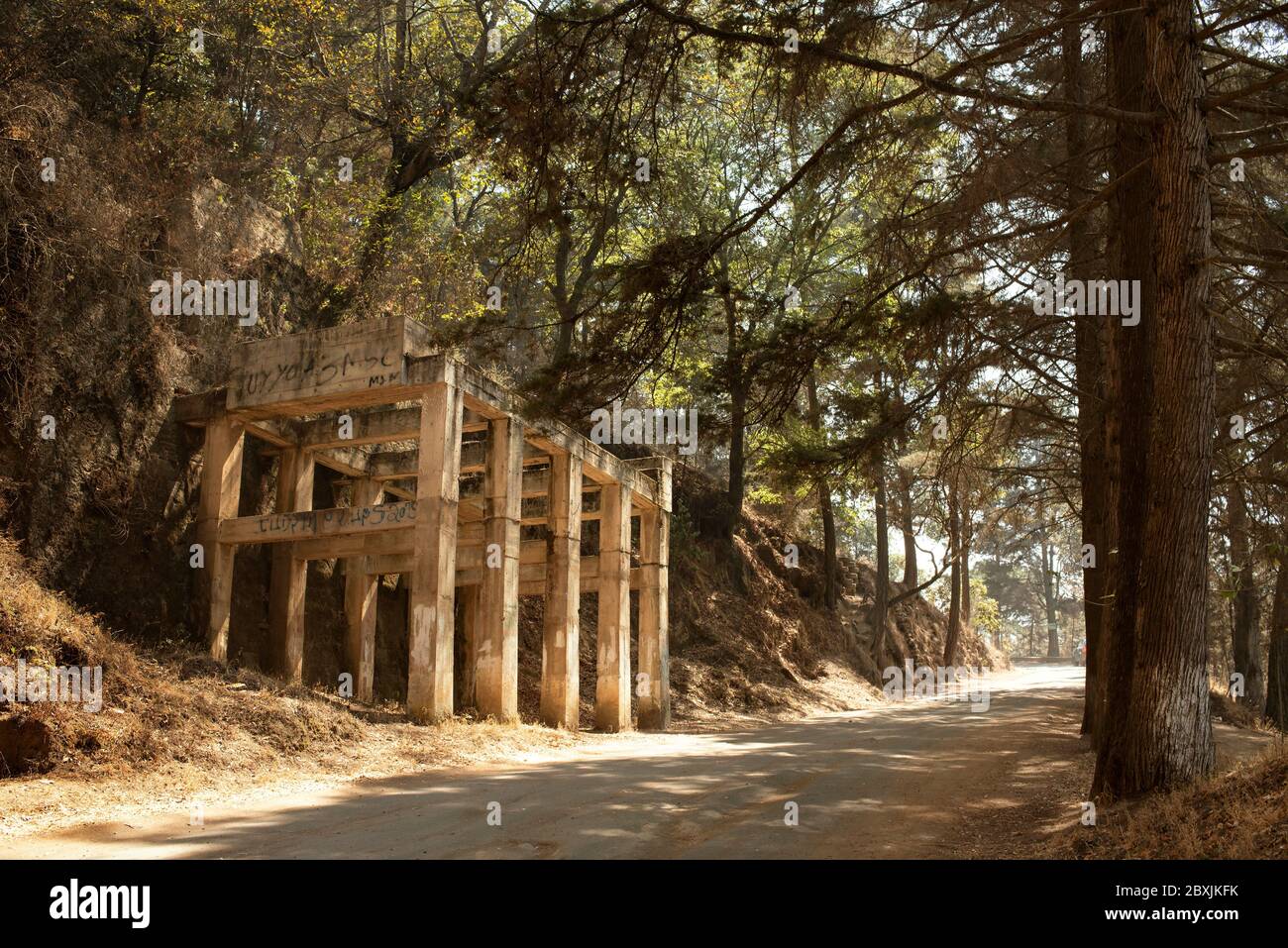 Abandoned concrete structure of a building alongside dirt road in Cerro El Baúl national park. Quetzaltenango, Guatemala. Mar 2019 Stock Photo