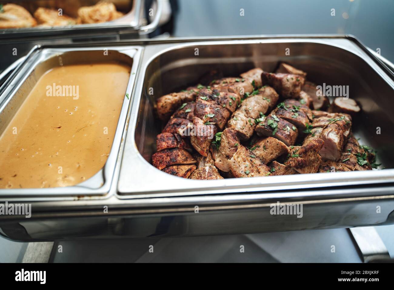 Row of stainless hotel pans on food warmers with various meals.  Self-service buffet table. Celebration, party, birthday or wedding concept.  Stock Photo