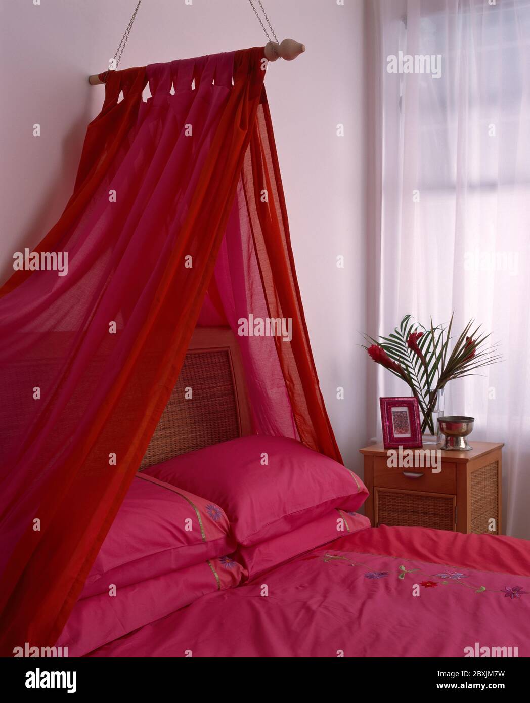 Fabric canopy suspended on curtain pole above bed Stock Photo Alamy