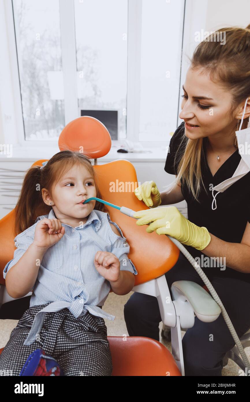 Dentist assistant ejecting saliva of girl Stock Photo Alamy