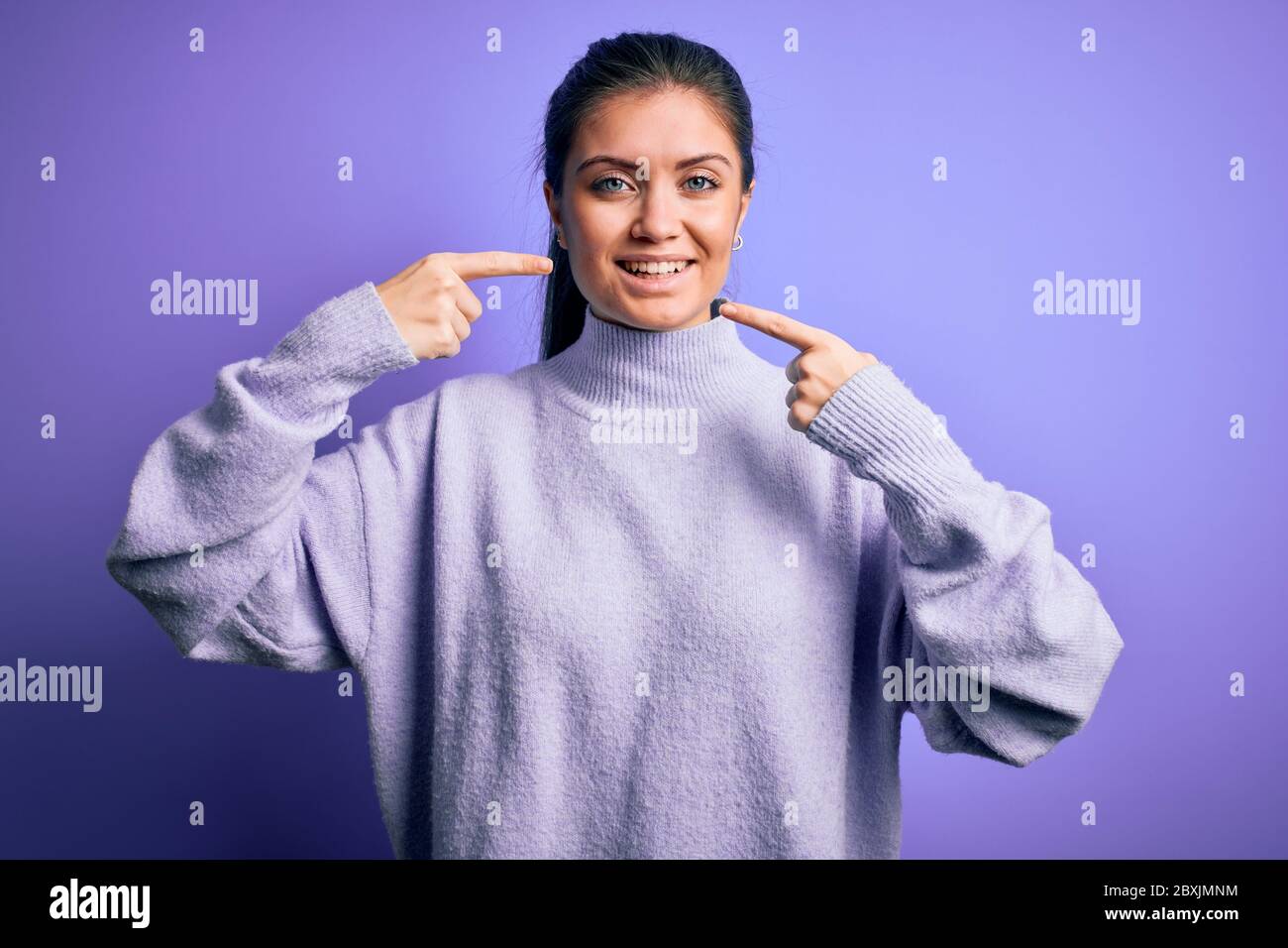 Young beautiful woman with blue eyes wearing casual turtleneck sweater ...