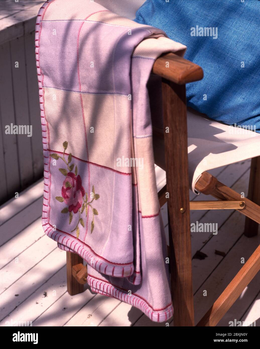 Embroidered throw over arm of deckchair Stock Photo