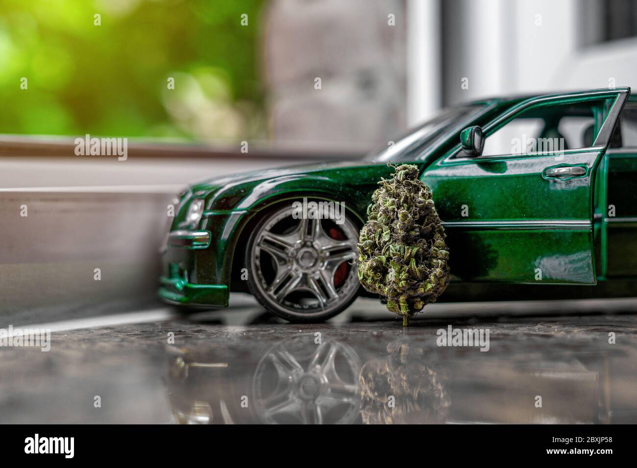 Dry marijuana bud in trichomes, rich in cannabinoids. Detailed cannabis girl scout cookies and a small car model. Creative shot Stock Photo