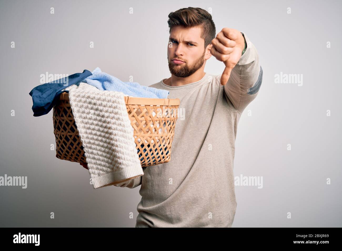 Young blond man with beard and blue eyes doing chores holding wicker ...
