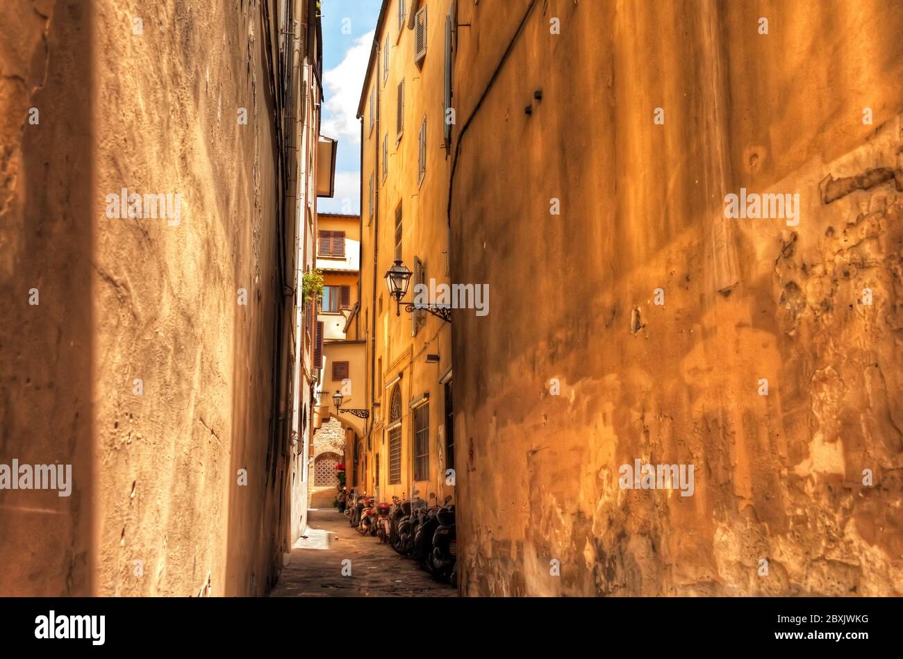 Traditional Narrow Italian Alley with Housing and Summer Sun in Florence, Italy Stock Photo