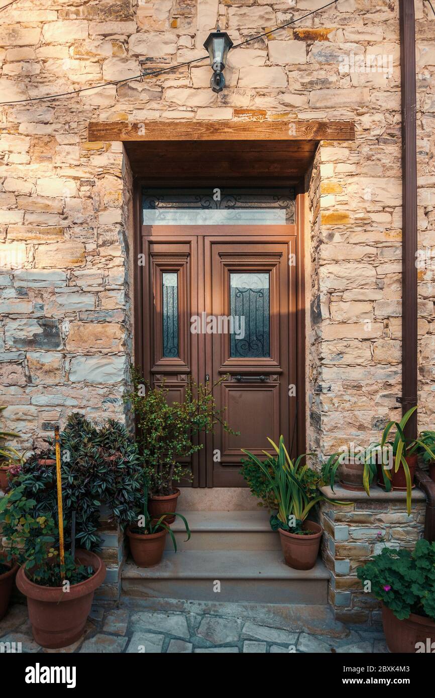 Elegant stone entrance, door with steps and flower pots Stock Photo - Alamy