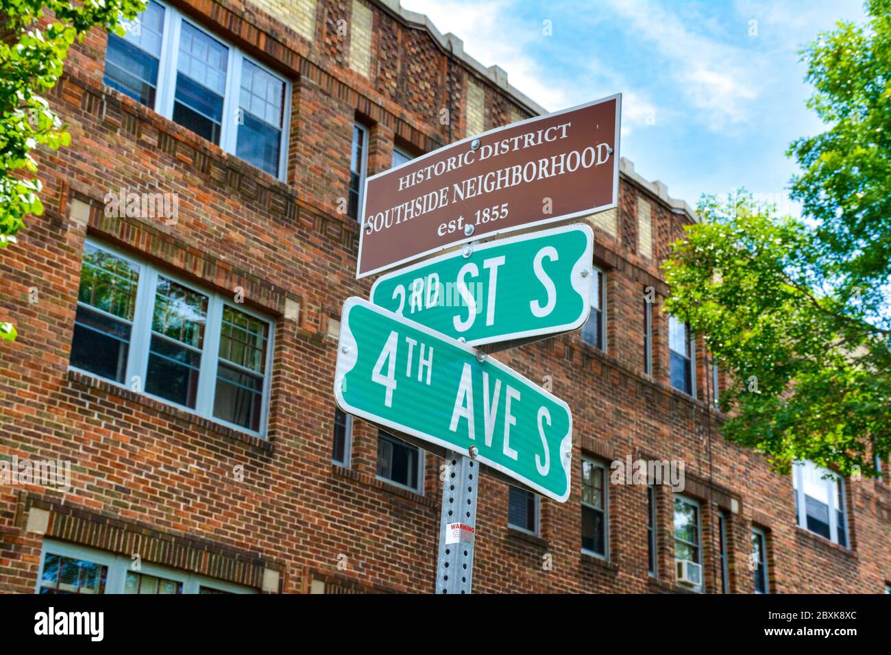 Street signs and an Historic District Southside Neighborhood marker before an old brick building in small town America, St. Cloud, MN, USA Stock Photo