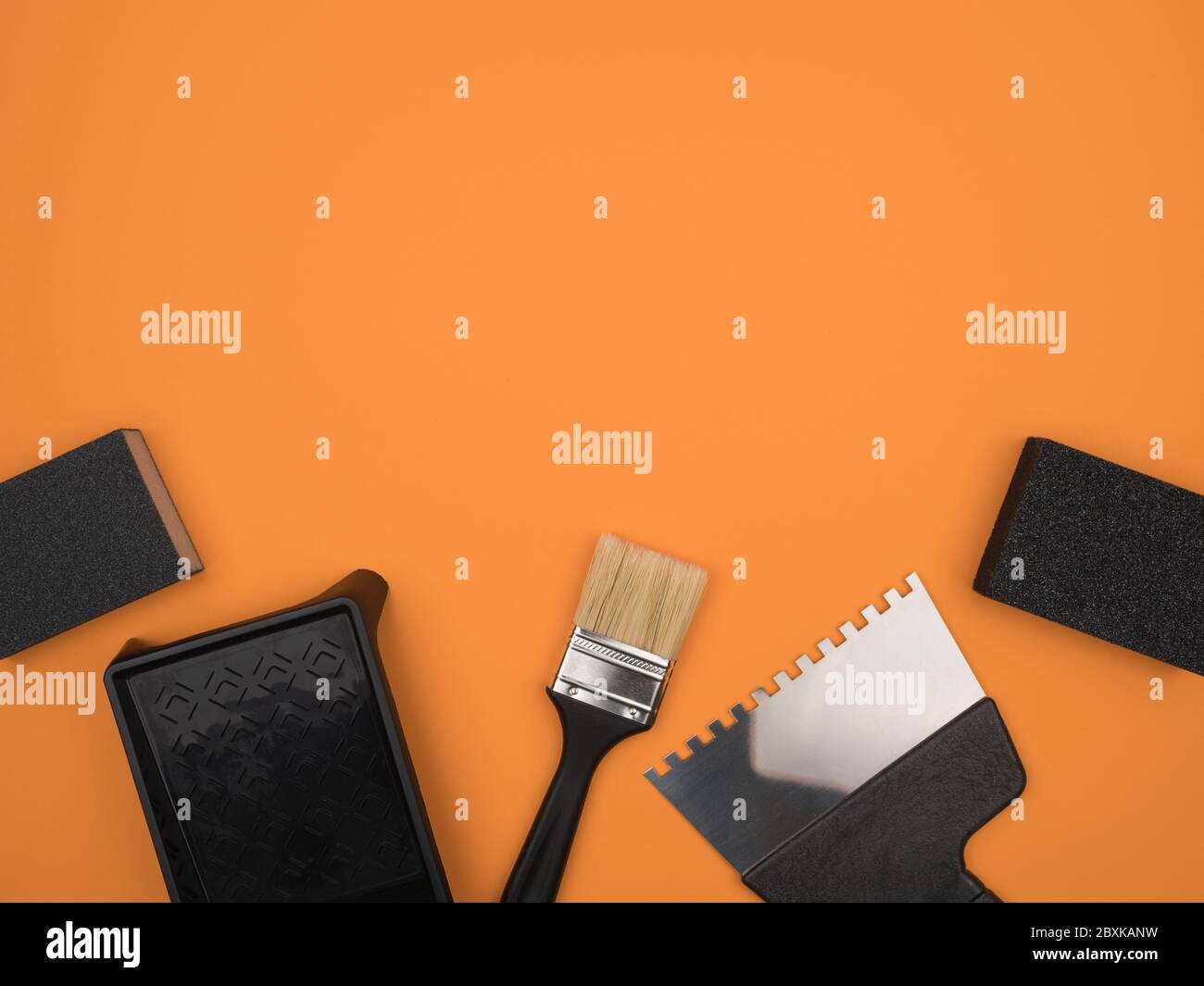 Black tool on a orange background. Paint tool. Stock Photo
