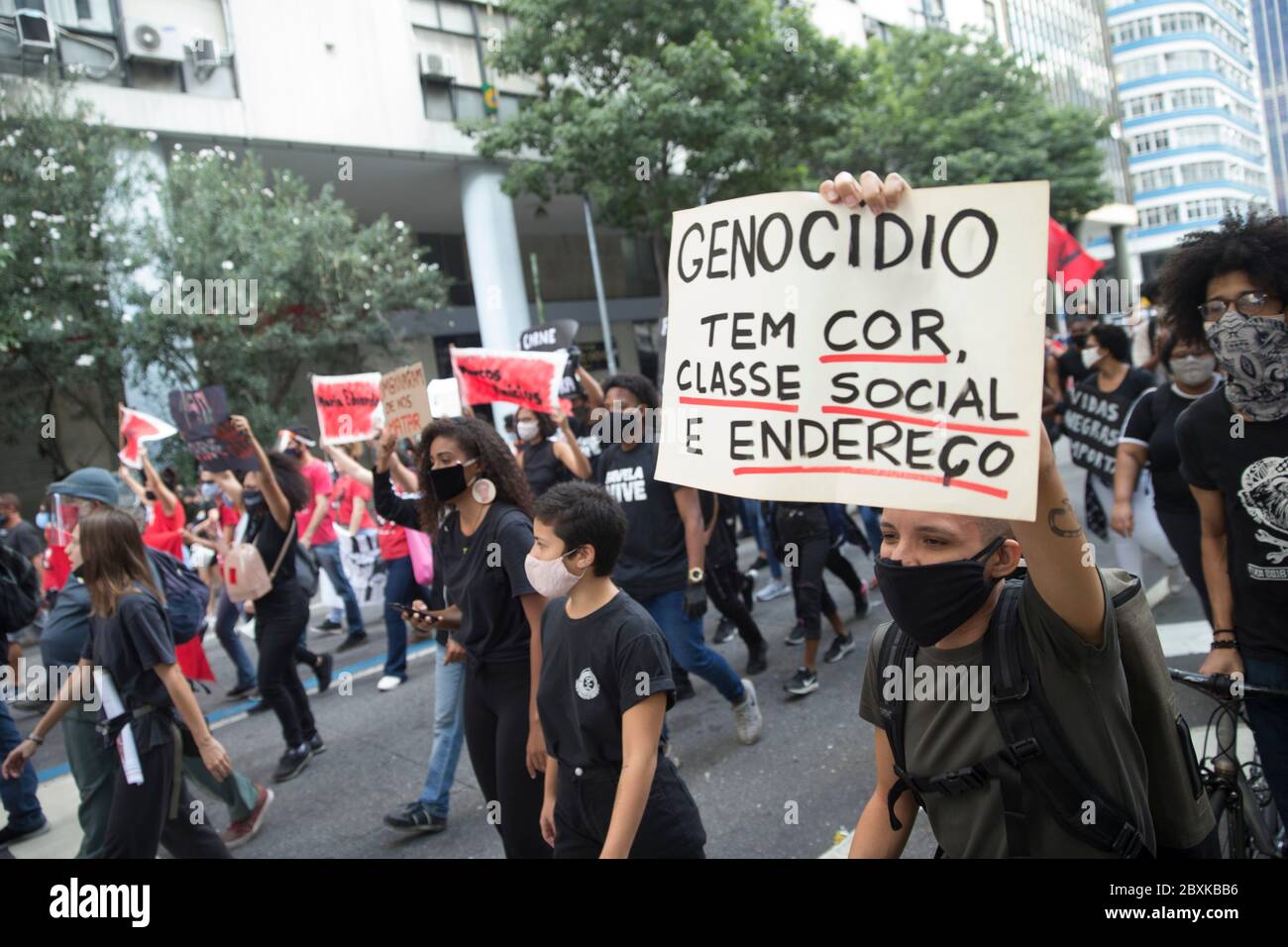 Rio de Janeiro, Brazil. 7th June, 2020. Protesters took to the streets during the Covid-19 pandemic, during a Black Lives Matter rally, in protest against the racism and death of black people, including George Floyd in the USA, and Joao Pedro in Rio. In the photo, a demonstrator holds a sign that says "Genocide has color, social class and address". Credit: Fernando Souza/ZUMA Wire/Alamy Live News Stock Photo