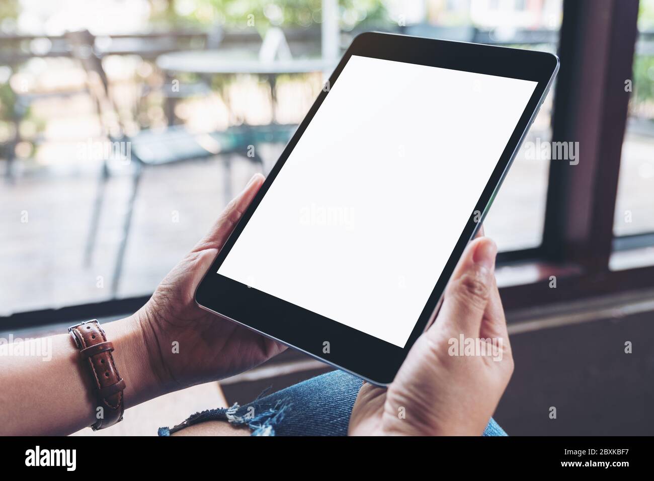 Mockup image of hands holding black tablet pc with blank white screen ...