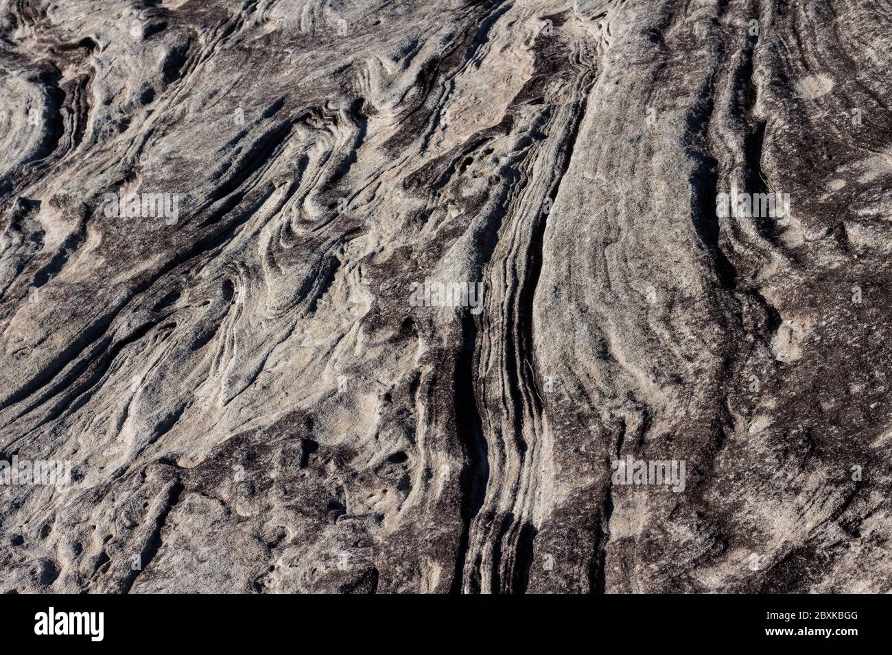 Natural sandstone rock rippled textured surface ideal as background Stock Photo