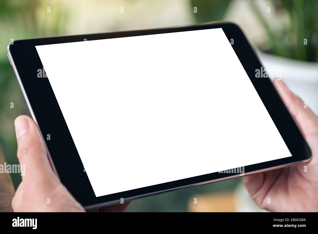 Mockup image of hands holding black tablet pc with blank white screen ...
