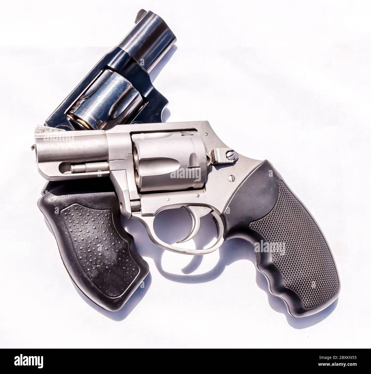 Two handguns, a stainless steel 357 and a black 38 special revolver on a white background Stock Photo