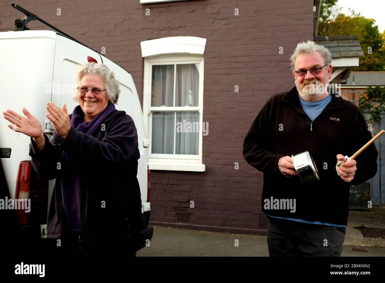 Clap for the NHS couple outside their house on the roadside smiling and clapping Stock Photo