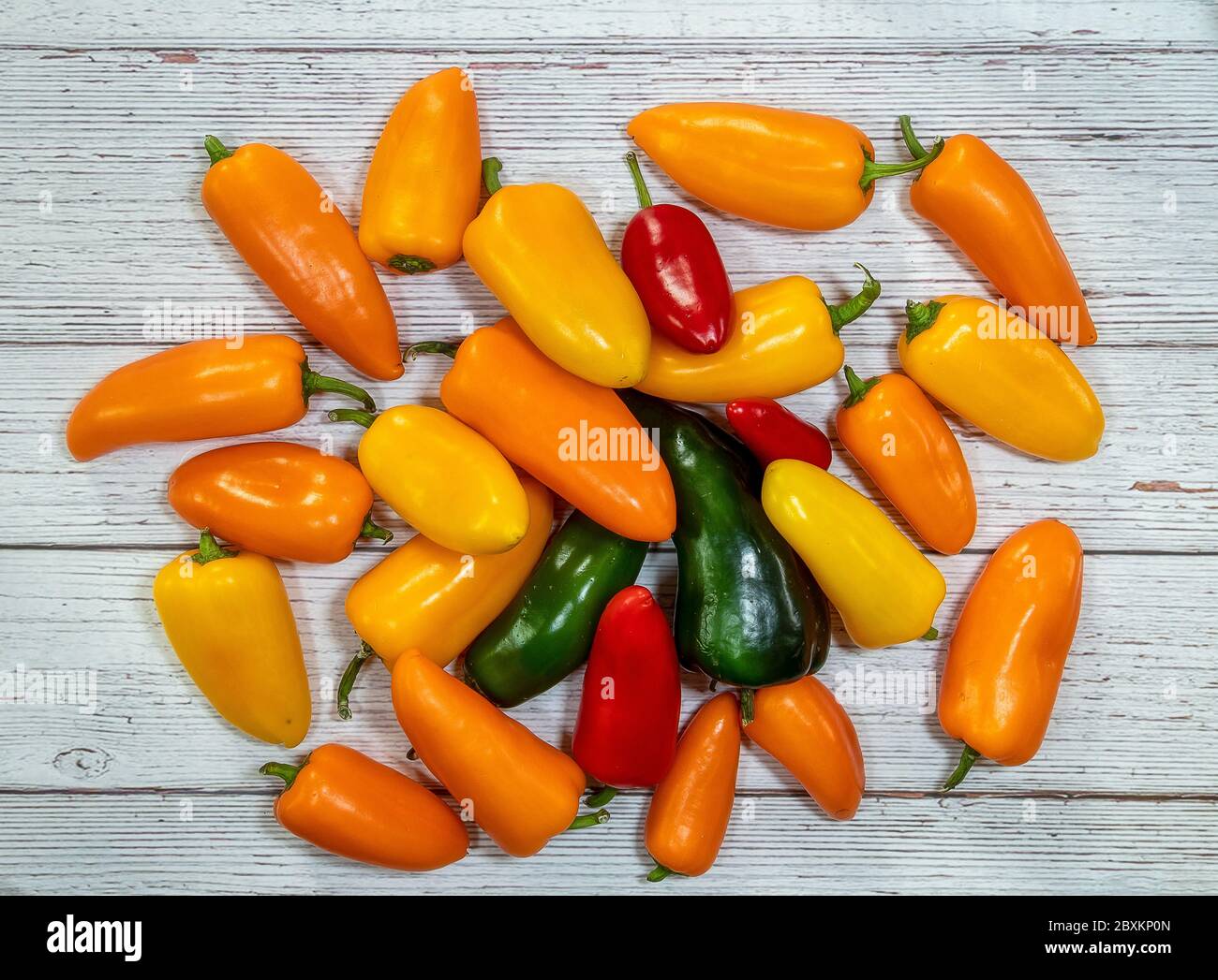 Group of whole fresh pepper flatlay on a wooden background Stock Photo