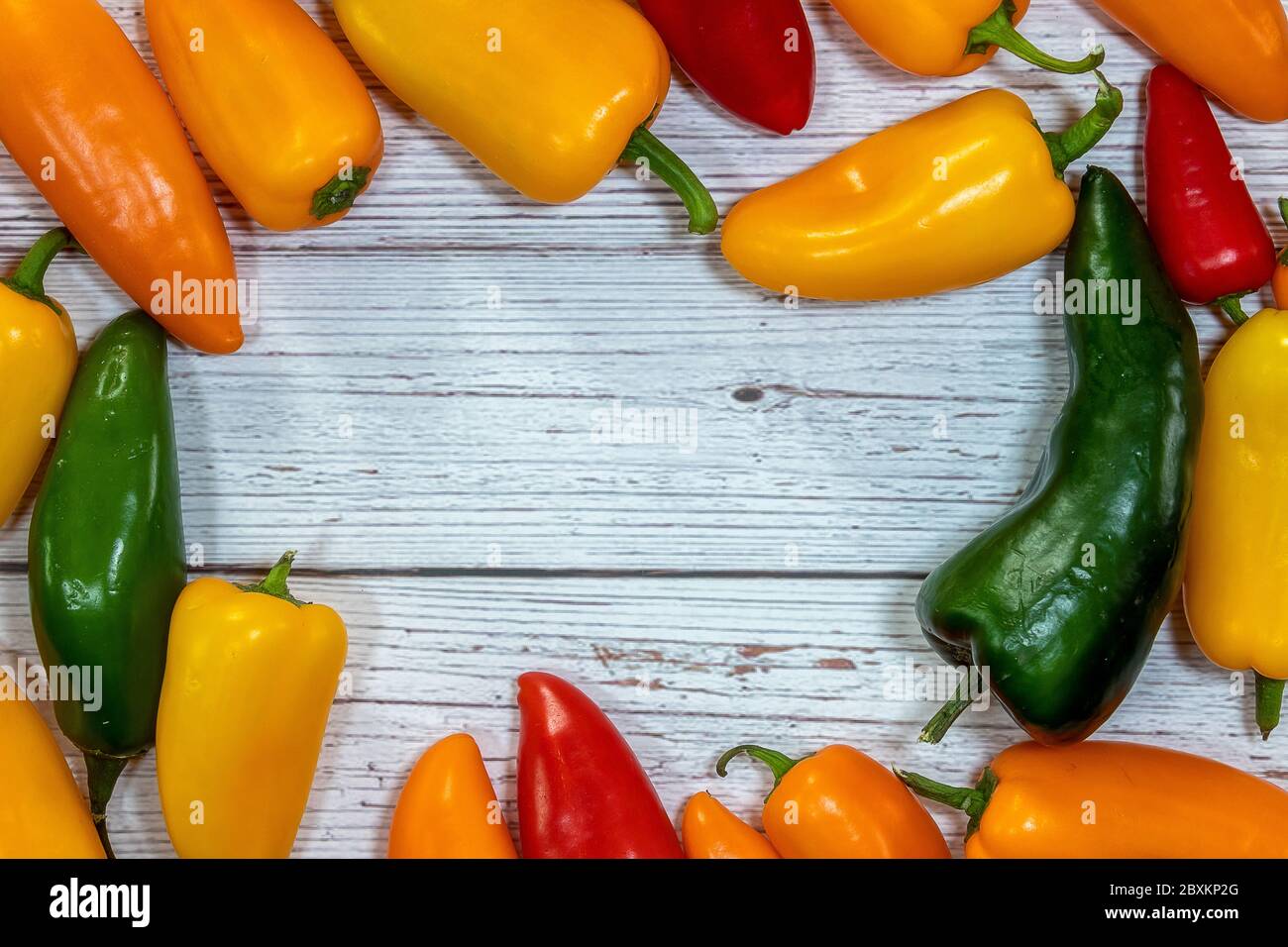 Group of whole fresh pepper flatlay on a wooden background Stock Photo