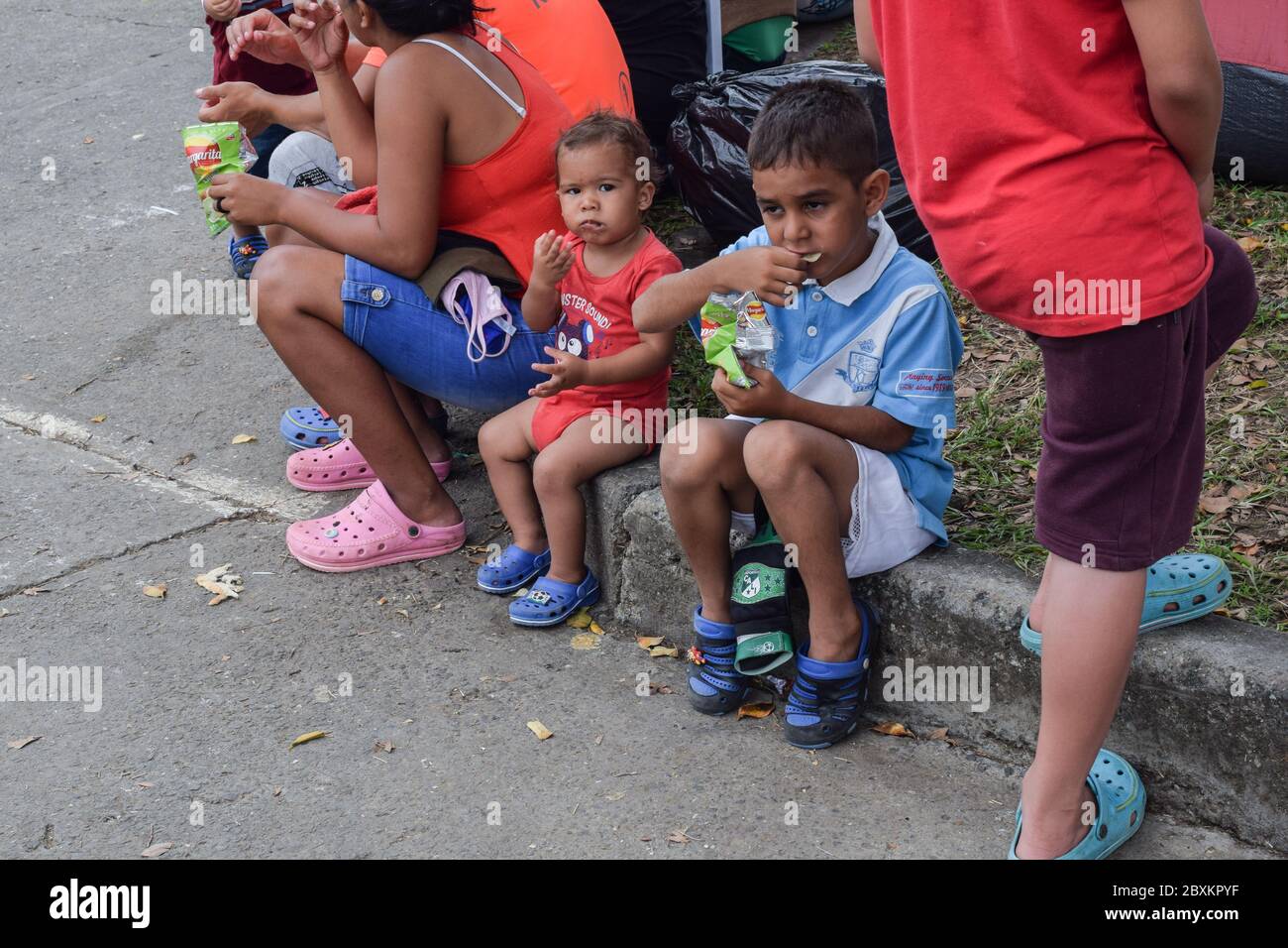 Members of 'Jesús Pescador de Hombres' foundation giving food aid to stranded Venezuelans in Cali. The organisation prepares and distributes hundreds Stock Photo