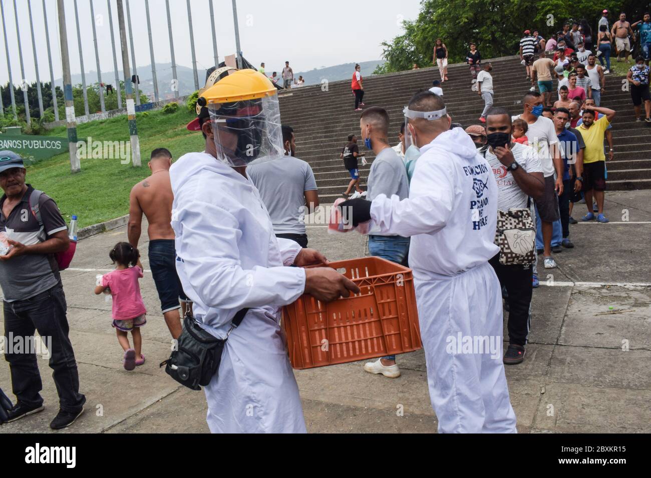 Members of 'Jesús Pescador de Hombres' foundation giving food aid to stranded Venezuelans in Cali. The organisation prepares and distributes hundreds Stock Photo
