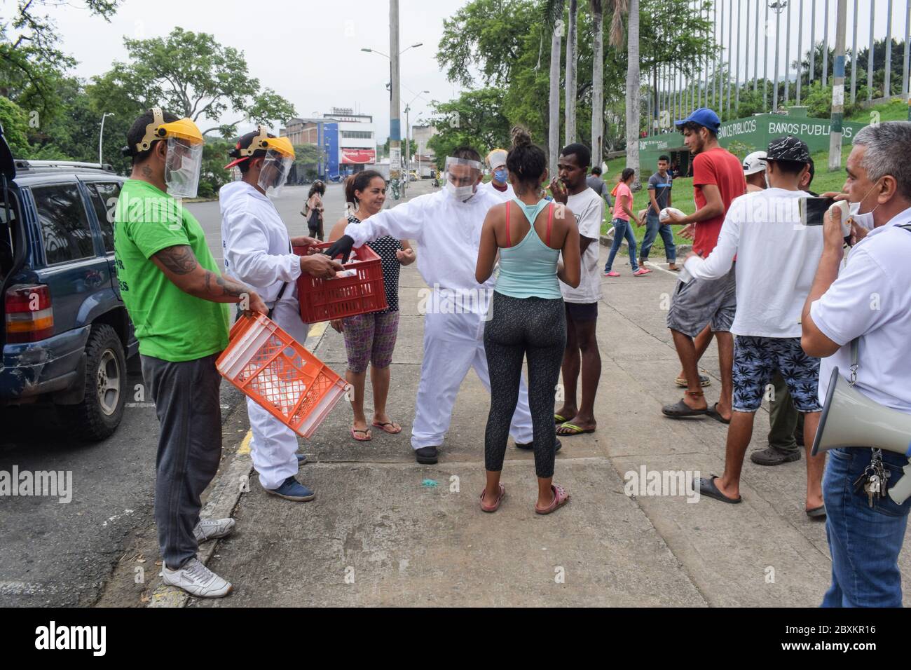 Members of 'Jesús Pescador de Hombres' foundation giving food aid to stranded Venezuelans in Cali. The organisation prepares and distributes hundreds Stock Photo