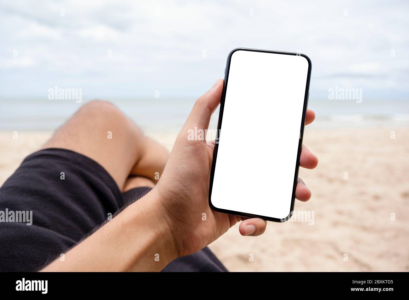 Download Mockup Image Of A Hand Holding And Showing Black Mobile Phone With Blank Desktop Screen While Sitting On The Beach Chair Stock Photo Alamy