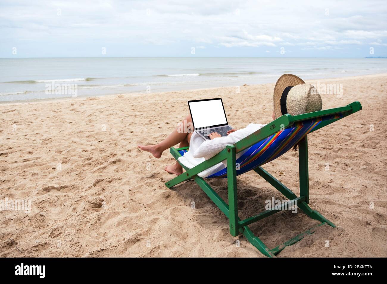 Download Mockup Image Of A Woman Using And Typing On Laptop Computer With Blank Desktop Screen While Lying Down On A Beach Chair Stock Photo Alamy