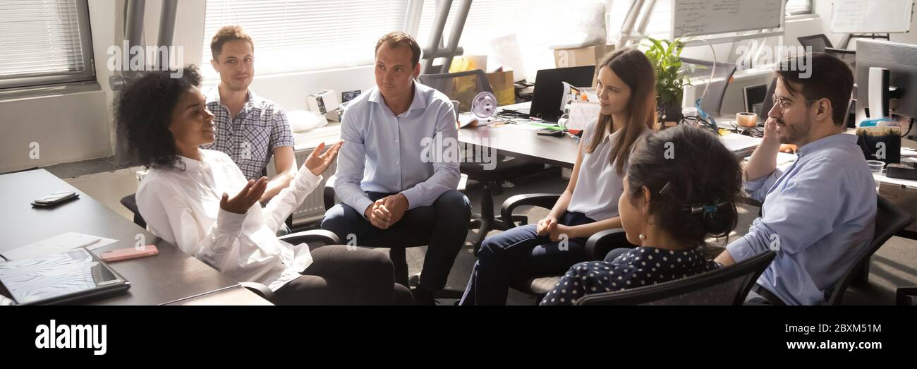 Diverse employees gathered brainstorming together in co working office ...