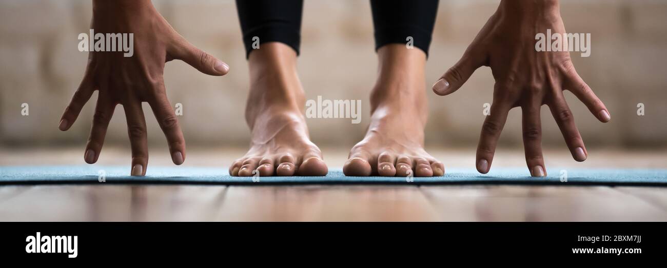 Woman practising yoga forward bend or uttanasana position closeup image Stock Photo