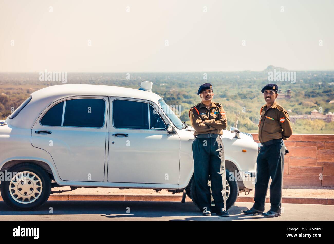 JODHPUR, INDIA - 09 FEB, 2014 - Two Indian policemen standing next to white Indian retro car near Umaid Bhawan Palace Stock Photo