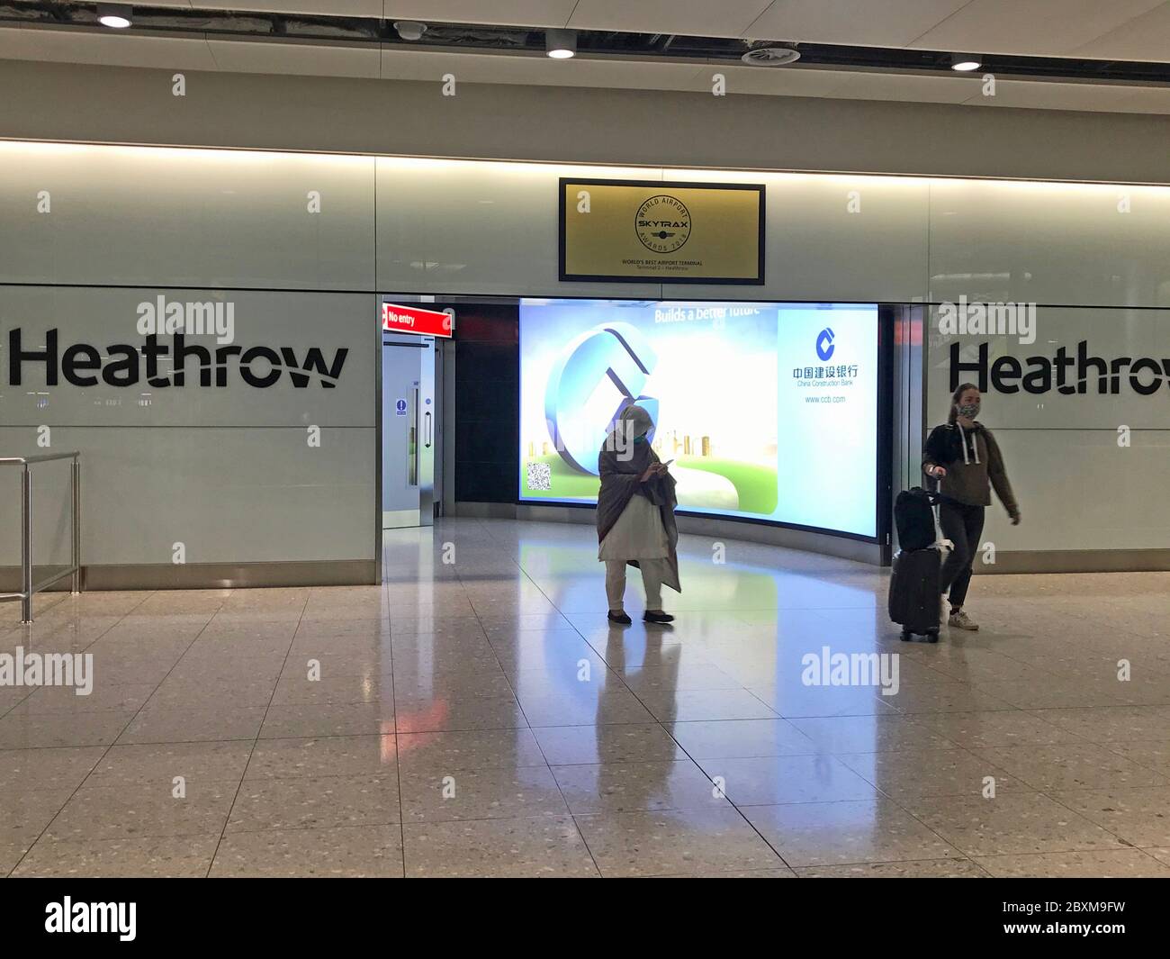 People come into the arrivals lounge in Terminal 2 at Heathrow Airport in London, as new quarantine measures for international arrivals come into force. Stock Photo