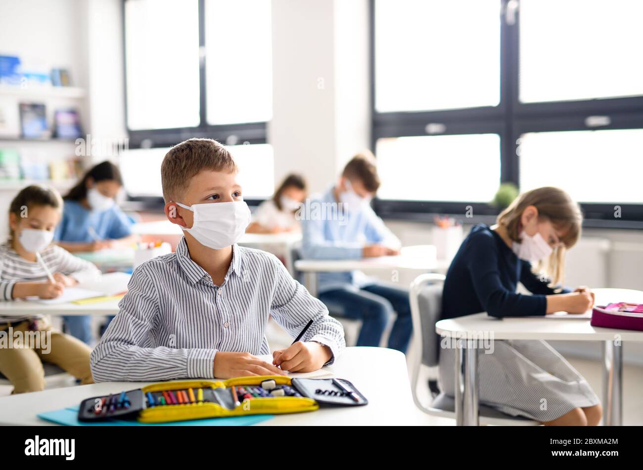 Children with face mask back at school after covid-19 quarantine and lockdown. Stock Photo