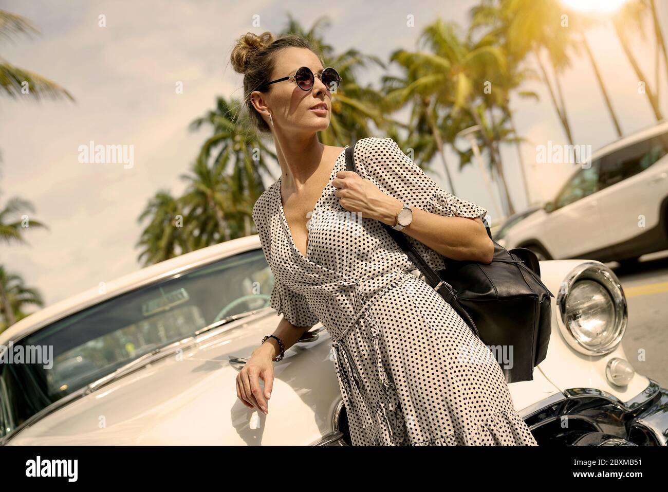 Stunning stylish young woman standing infront of vintage car Stock